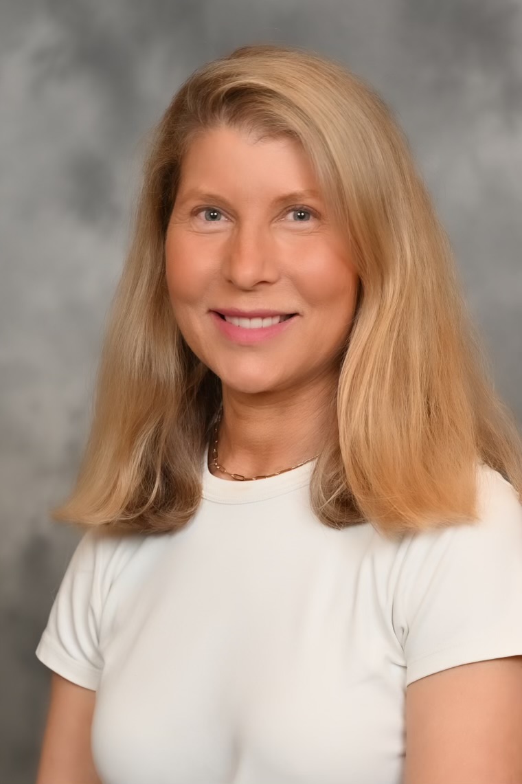 A picture of a woman with blonde hair wearing a white shirt.